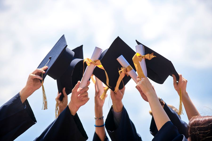 Graduates celebrating with caps and diplomas