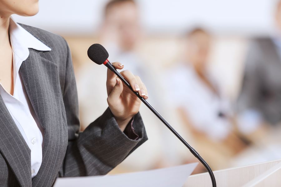 Speaker holding a microphone at a business conference