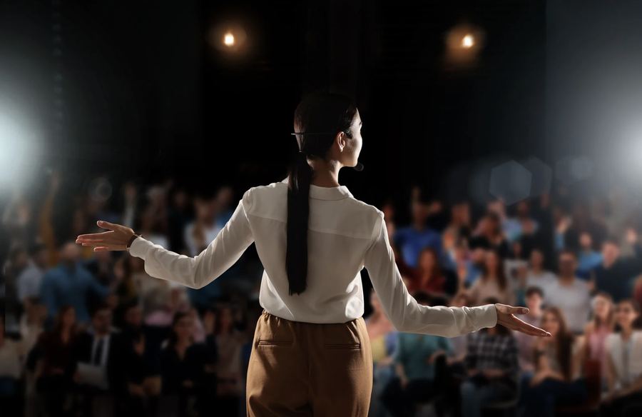 A speaker presenting confidently to an audience